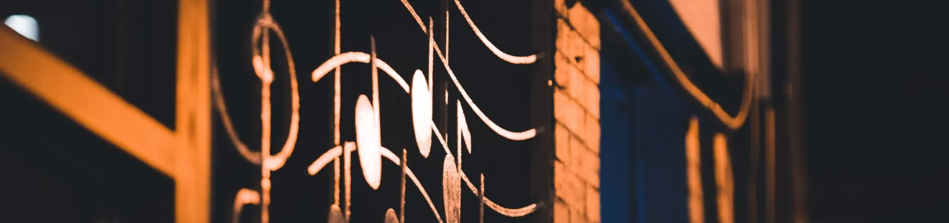 Metallic musical note decoration on building facade at night.