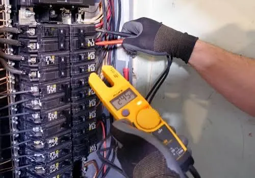 Detailed view of an open electrical switchboard with tangled wires and cables.