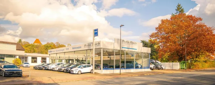Charming auto dealership in Baine, Germany, accented by vibrant autumn foliage.