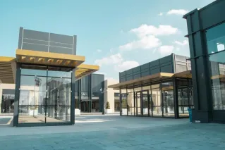 Empty modern urban space with glass facades under a clear sky.