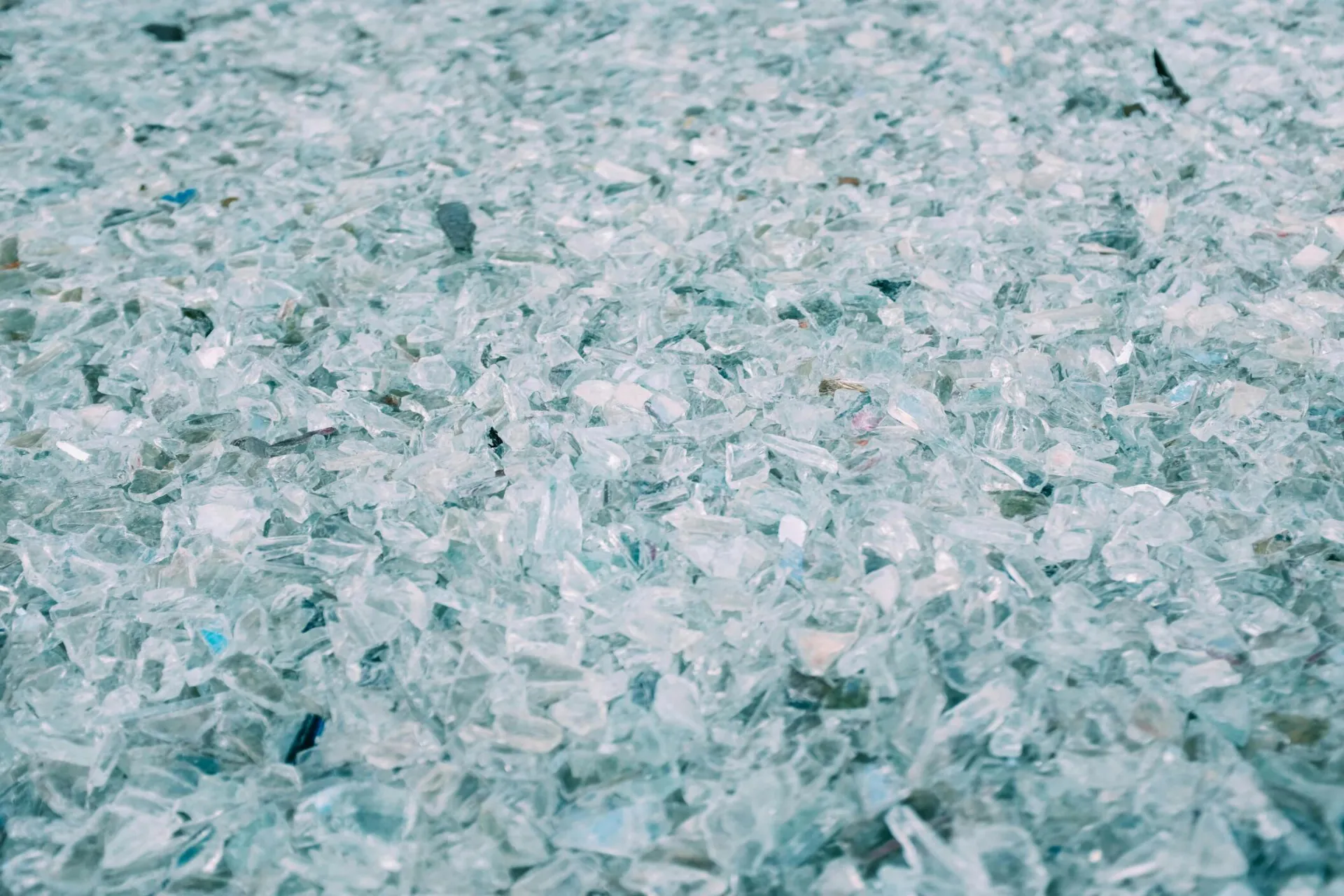 High detail close-up of shattered and scattered turquoise glass pieces with a soft focus.