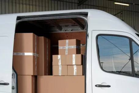 Delivery van loaded with cardboard boxes for global shipping logistics.