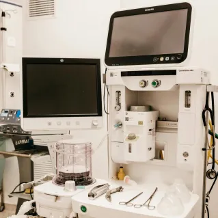 High-tech medical equipment setup in a hospital room, featuring monitors and surgical tools.