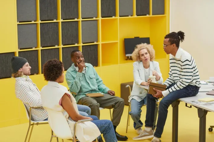 A diverse group of coworkers engaged in a creative brainstorming session in a modern office.