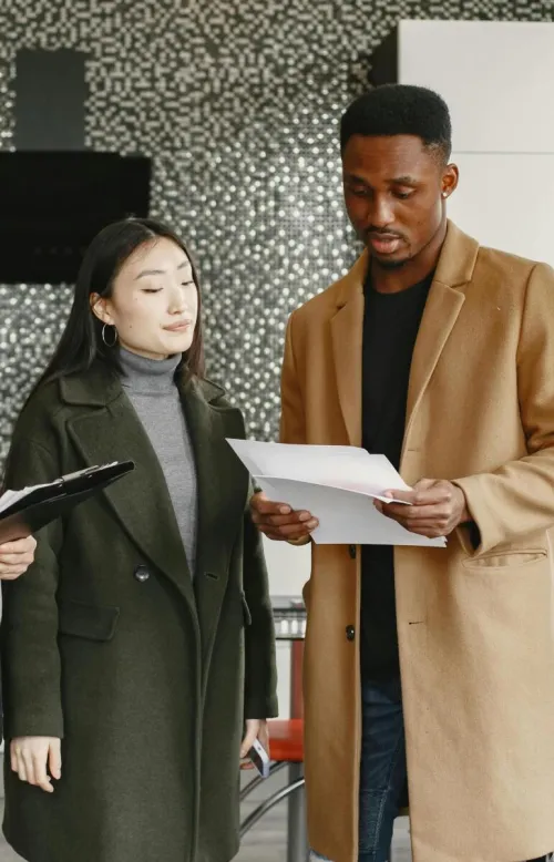Three colleagues reviewing business documents in a modern office setting.