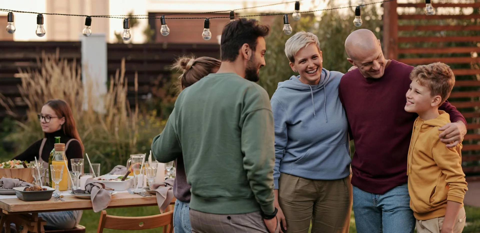 Family and friends enjoying a summer garden gathering with food and laughter.