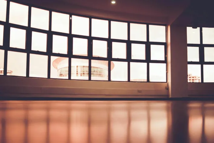 Spacious modern interior featuring expansive glass windows showcasing an urban building facade.