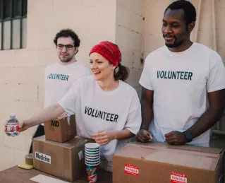 Volunteers distributing aid at an outdoor donation center, promoting social impact and diversity.