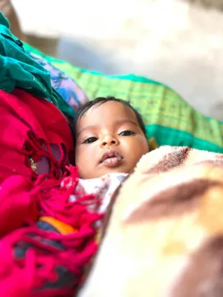 Cute baby wrapped warmly in vibrant blankets, creating a cozy and comforting scene.