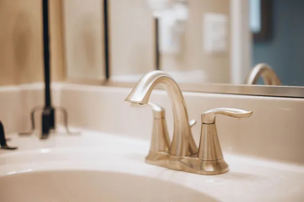 Close-up of a sleek modern bathroom faucet reflecting elegance and luxury.