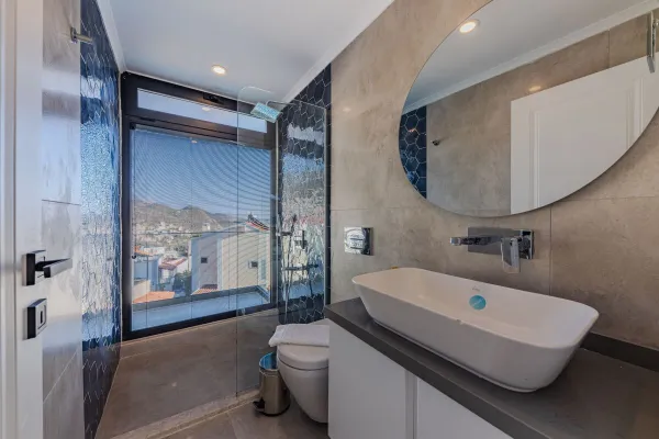 Explore a contemporary bathroom featuring luxury fittings and a scenic window view.