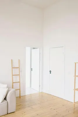 A serene minimalist room featuring natural wood accents and white walls.