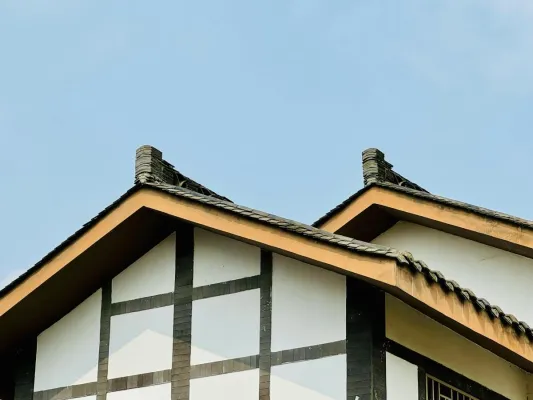 Capture of a traditional timbered roof with architectural features under a clear blue sky.