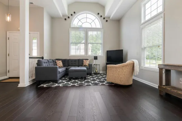 Bright living room with modern furniture, high ceilings, and big windows.
