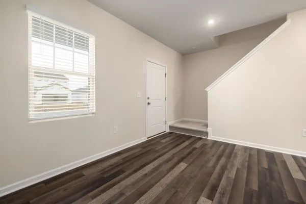 A bright, minimalist home interior showcasing wooden floors and natural light.