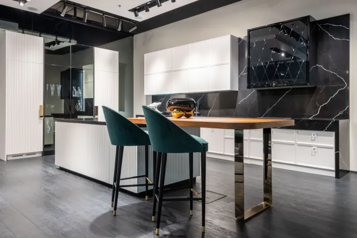 Contemporary trendy kitchen interior with black and white cabinets and cozy high chairs in modern apartment