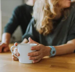 A relaxed scene of two people enjoying coffee indoors in a casual setting.