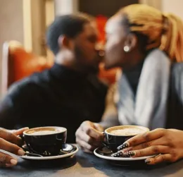 A loving couple enjoying a romantic moment over coffee in a warm cafe setting.