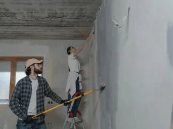 A couple painting a room together, highlighting teamwork in home renovation.