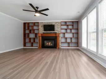 Spacious living room featuring a fireplace, built-in shelving, and large windows.