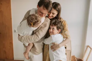 A heartwarming scene of a family hugging indoors, showcasing love and togetherness.