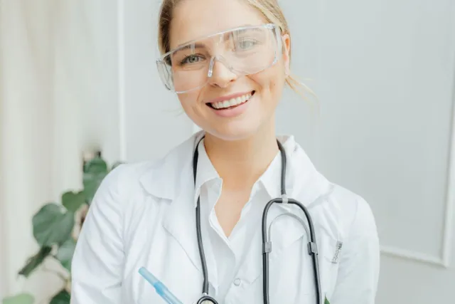 Confident female doctor with clipboard in a bright medical office.