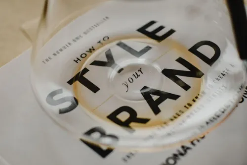 A coffee pot rests atop a book titled 'How to Style Your Brand', capturing the essence of creative branding.