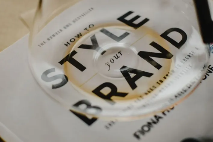 A coffee pot rests atop a book titled 'How to Style Your Brand', capturing the essence of creative branding.