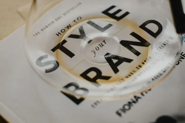 A coffee pot rests atop a book titled 'How to Style Your Brand', capturing the essence of creative branding.