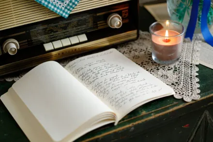 A vintage radio, candle, and journal create a nostalgic and cozy atmosphere indoors.