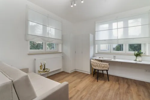 Bright and airy room with modern minimalist decor featuring wooden floors and ample natural light.