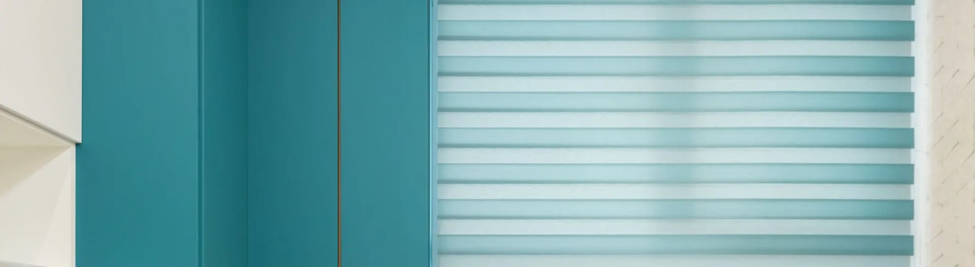 Open drawer against cabinet with vase on shelf and window blind in modern kitchen at home