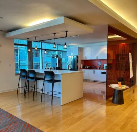 Modern kitchen interior with decorative vase on shelf of cabinet and window blind against table in house