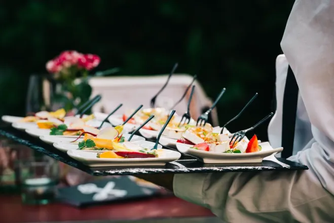 Gourmet appetizers elegantly served on tray at outdoor event, highlighting culinary artistry.