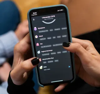 Close-up of woman using a smartphone health tracking app, focusing on personal wellness data.