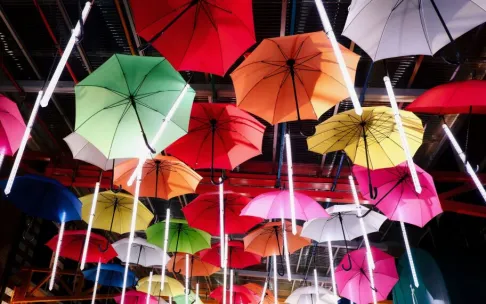 Colorful umbrellas create a striking display in a modern urban environment, adding artistic flair.