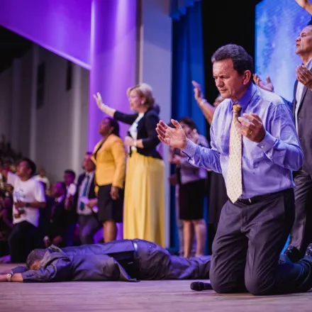 A diverse group of people engaged in a spiritual worship service, expressing faith and devotion.