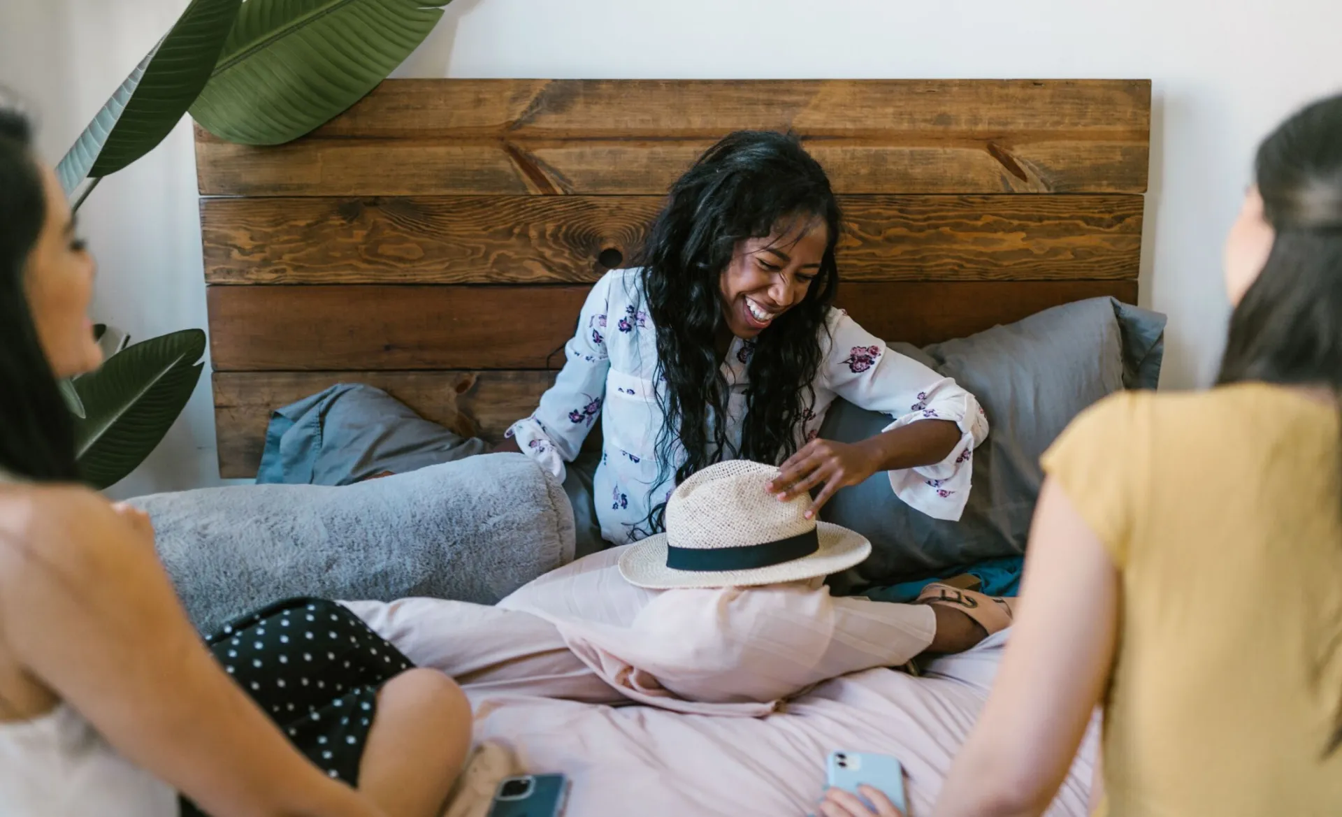 Three friends laughing and bonding indoors, sharing a joyful moment together.