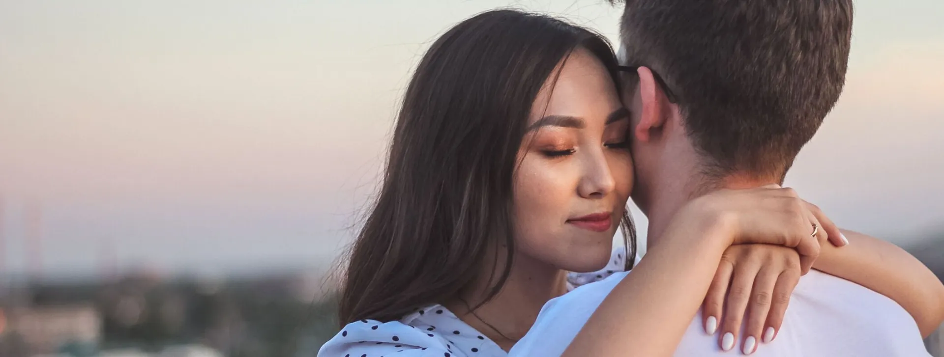 A tender embrace between a couple at sunset, showcasing love and intimacy.