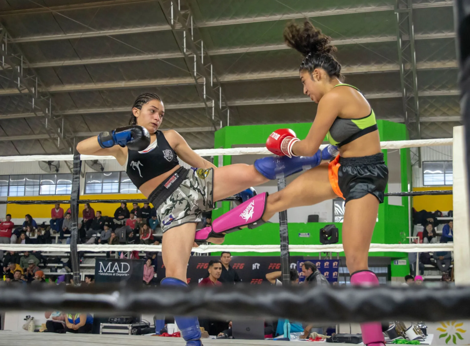 Two female athletes sparring in a kickboxing match, displaying skill and intensity.