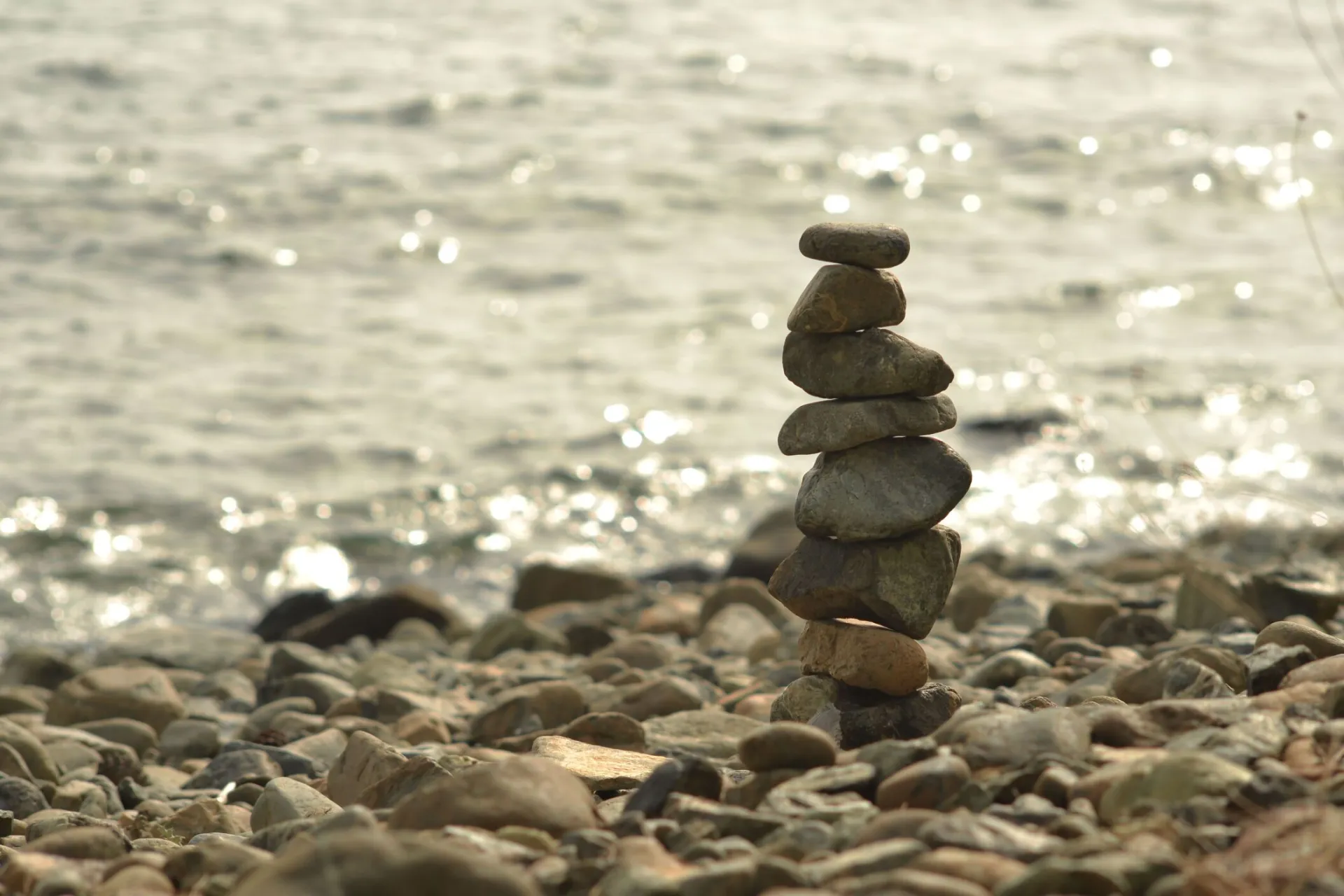 A peaceful stack of stones by the beach at sunset showcasing balance and tranquility.