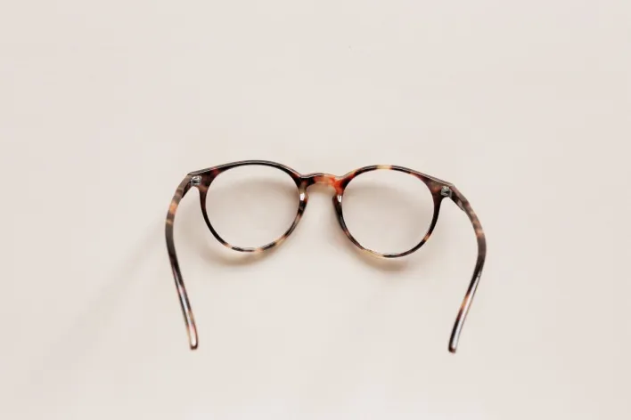 From above of fashion spectacles for vision of round shape in tortoise shell placed on white tabletop