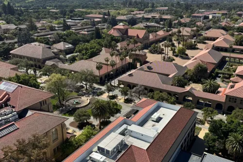 High-angle shot of Stanford University's distinctive red-roofed buildings and surrounding landscape.