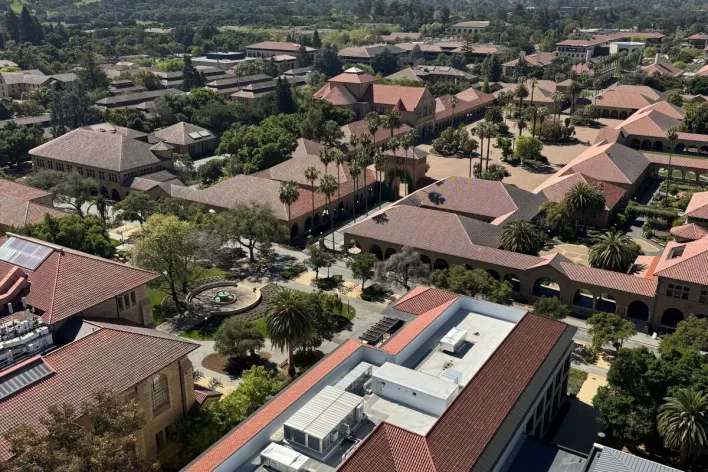 High-angle shot of Stanford University's distinctive red-roofed buildings and surrounding landscape.