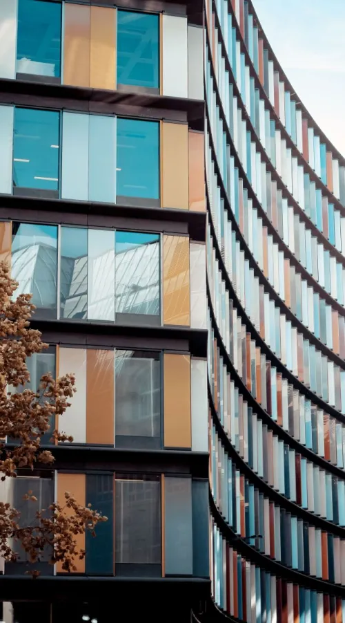 Curved glass facade of a modern building in urban London, showcasing contemporary architecture.