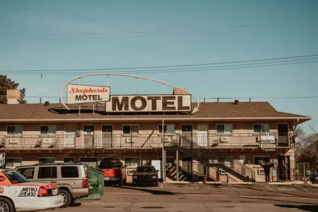 A nostalgic view of Shepherd's Motel with cars parked in front under a clear blue sky.