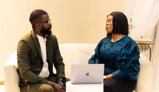 Two colleagues engaged in discussion in a Lagos office setting.