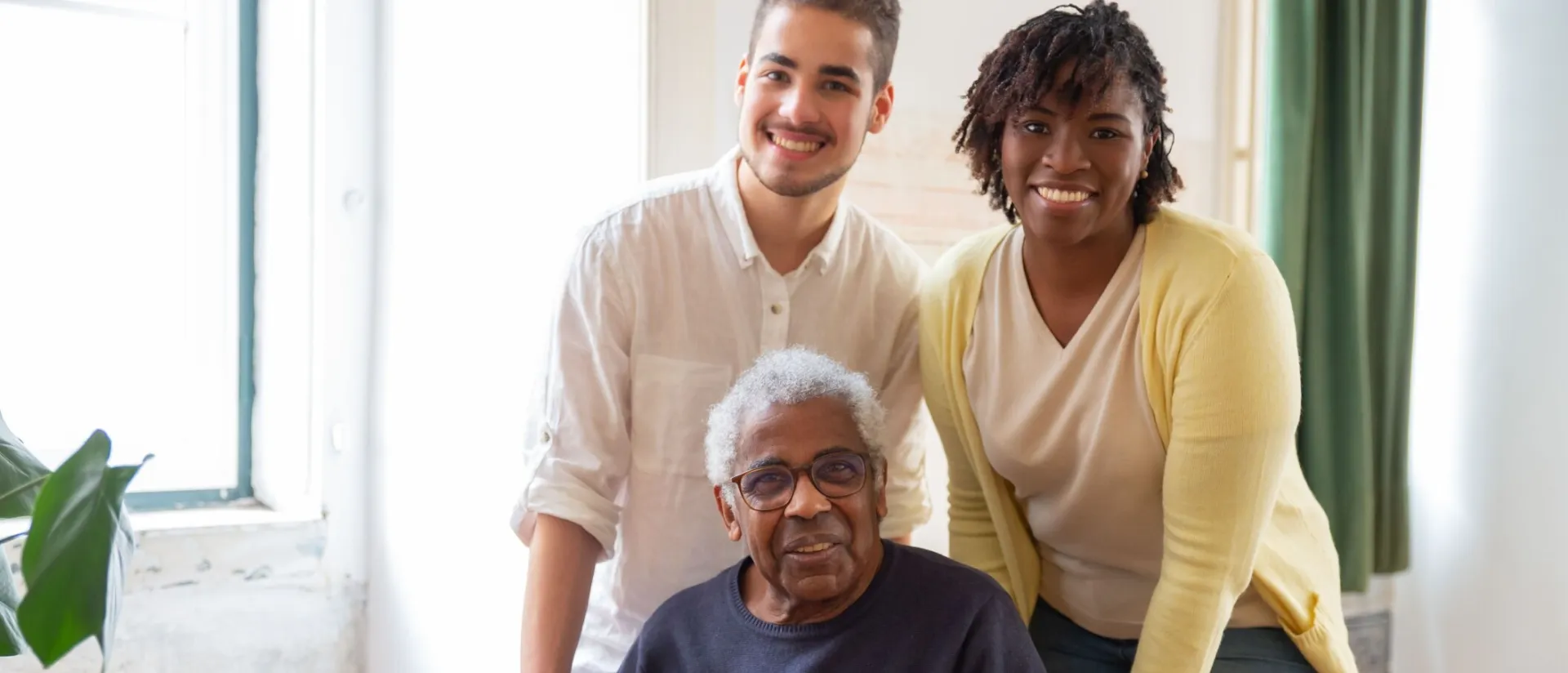 Happy multigenerational family smiling indoors, showing warmth and connection.