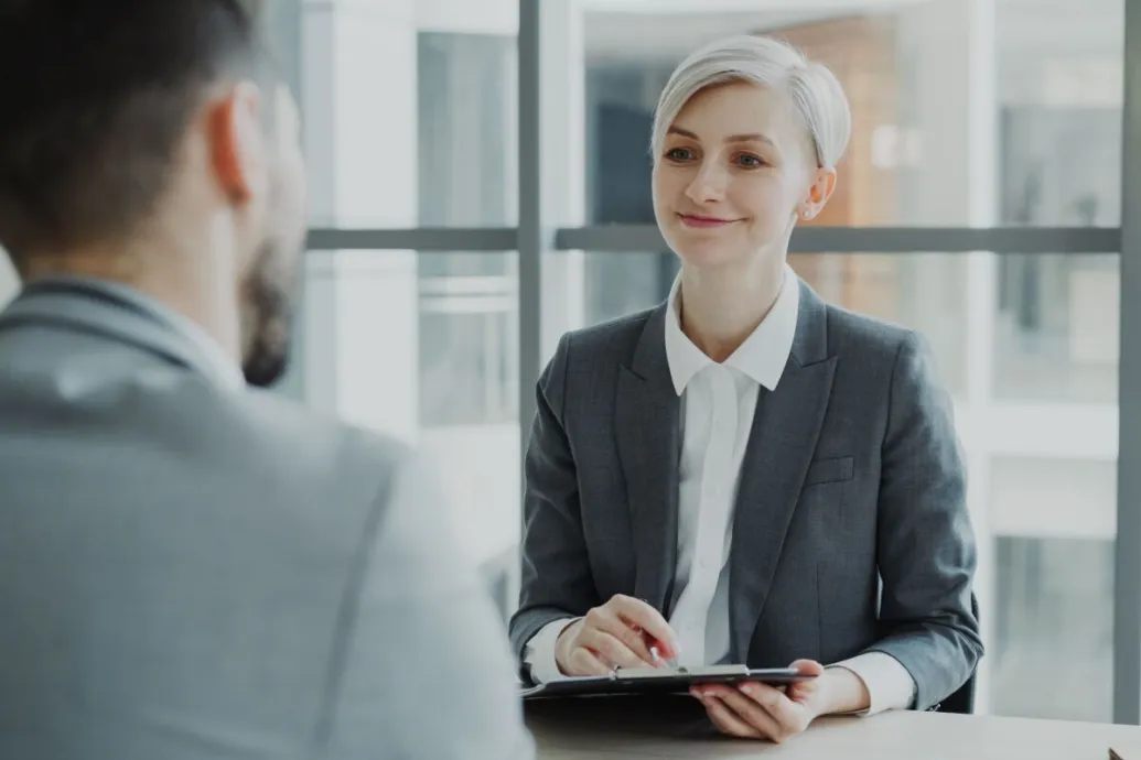 Confident woman interviewing candidate in a modern office. Ideal for business and HR visuals.