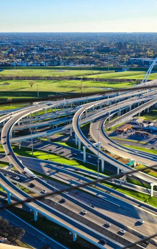 Aerial shot of a complex highway interchange with vehicles, showcasing urban infrastructure and connectivity.
